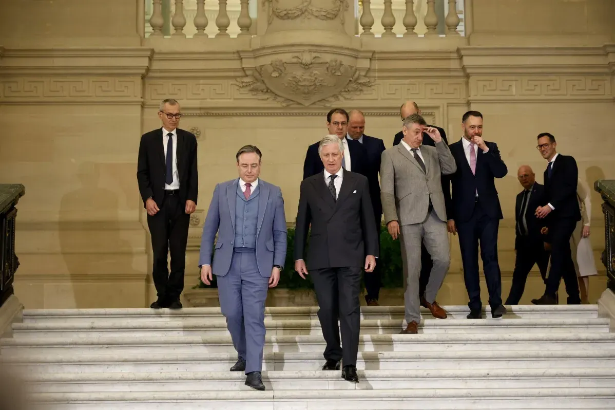 بارت دي ويفر، رئيس وزراء بلجيكا الجديد، يتقدم مع الوزراء أثناء مراسم القسم في القصر الملكي، مع التركيز على التوازن بين فلاندرز ووالونيا.