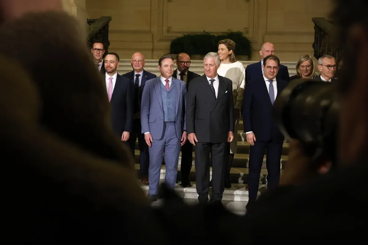 بارت دي ويفر، رئيس الوزراء البلجيكي الجديد، مع فريقه الوزاري خلال حفل أداء اليمين في القصر الملكي، يعكس التوازن اللغوي والسياسي في البلاد.