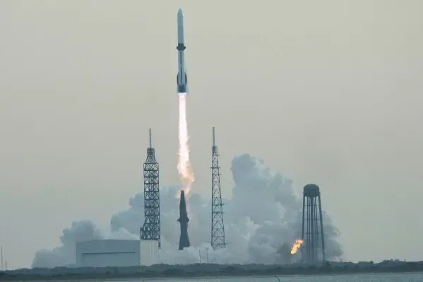 صاروخ New Glenn ينطلق من محطة Cape Canaveral، مع انطلاق الدخان والنار من محركاته، في محاولة لإيصال قمر صناعي إلى مداره.