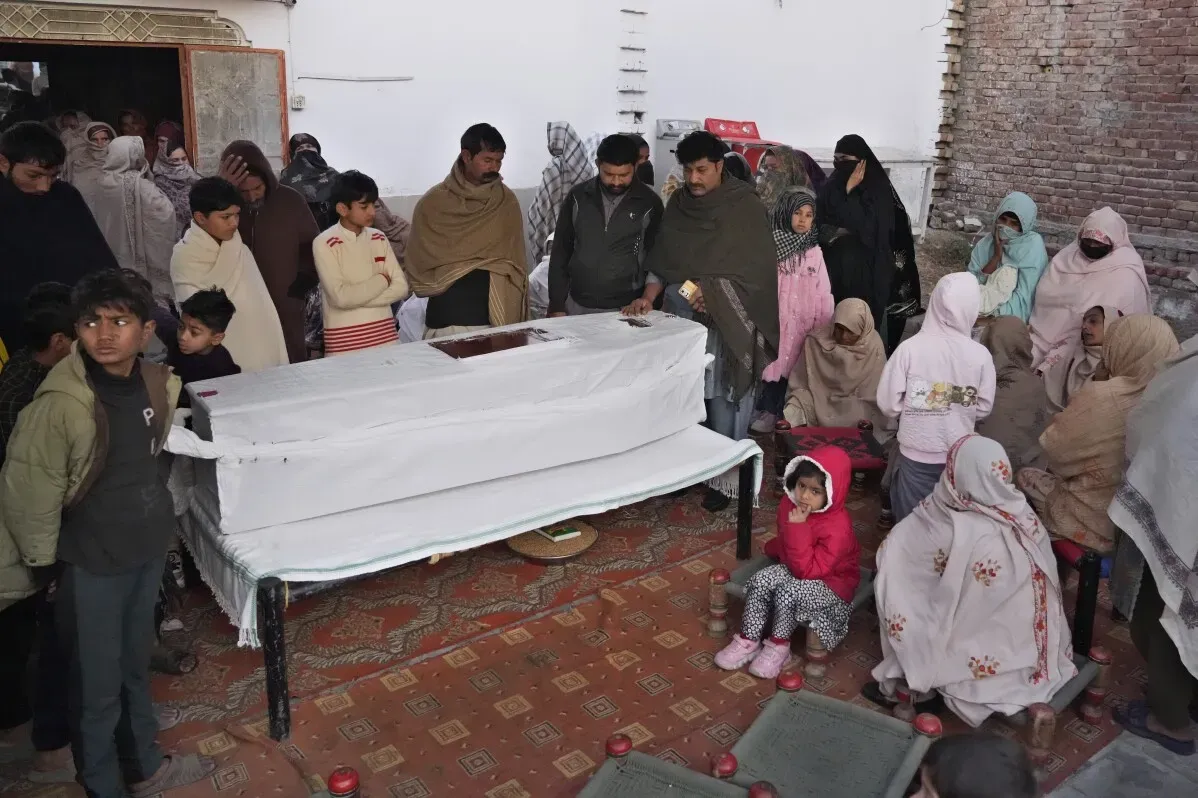 تجمع حشود من المعزين حول تابوت أبيض، في مشهد يعكس الحزن على فقدان أربعة باكستانيين غرقوا أثناء محاولة الهجرة.