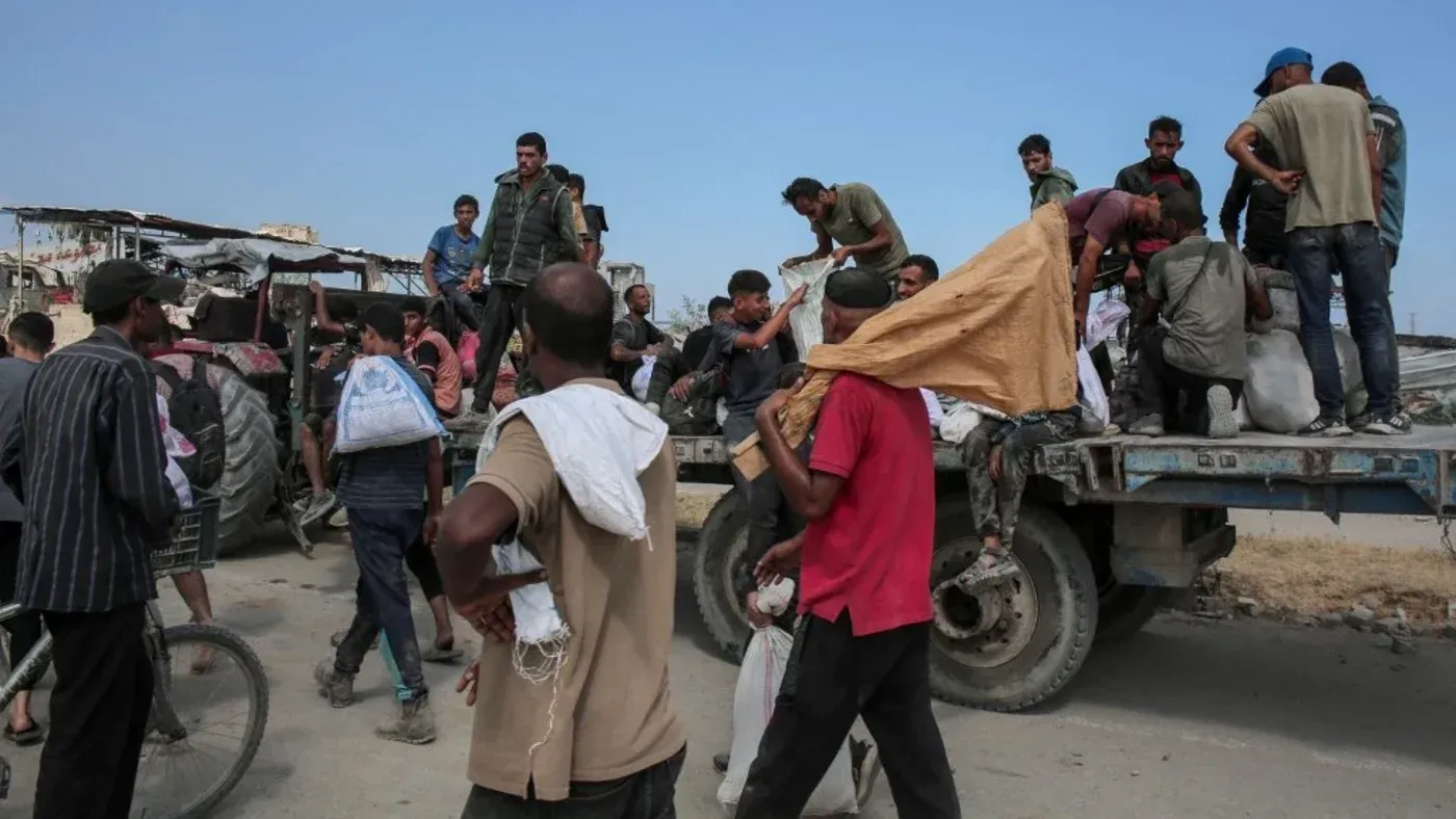 مشهد لعدد من الأشخاص في غزة يتجمعون حول شاحنة، يحملون أمتعتهم، في سياق خطط الترحيل إلى دول شرق أفريقيا.