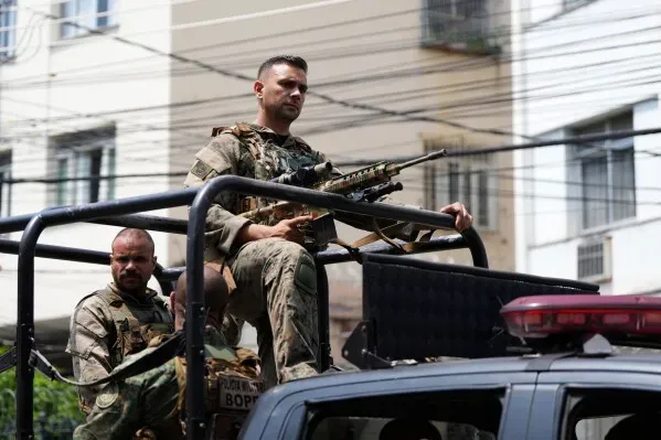 عناصر من الشرطة العسكرية في ريو دي جانيرو خلال عملية لمكافحة المخدرات، مع التركيز على الضباط المسلحين في مركبة.