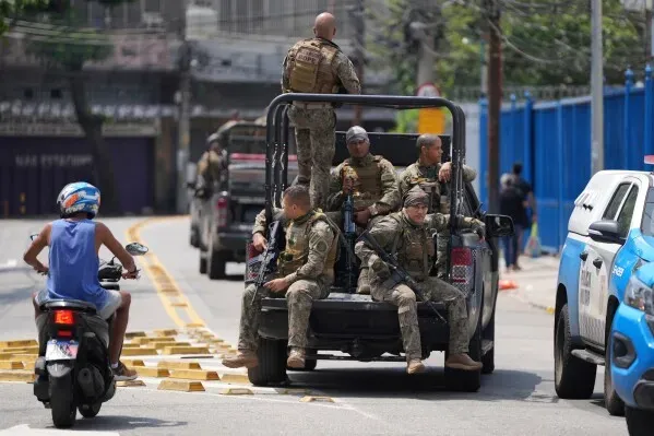 انتشار قوات الشرطة العسكرية في ريو دي جانيرو خلال عملية لمكافحة تهريب المخدرات، مع وجود ضباط مسلحين في شاحنة.