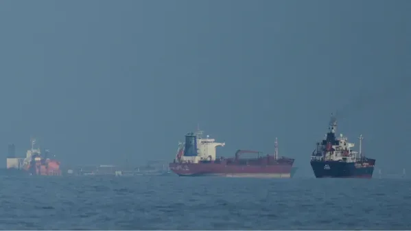 سفن شحن تبحر في مياه مضيق هرمز، مما يعكس تأثيرات الحرب على إيران والضغوط على أسعار النفط العالمية.