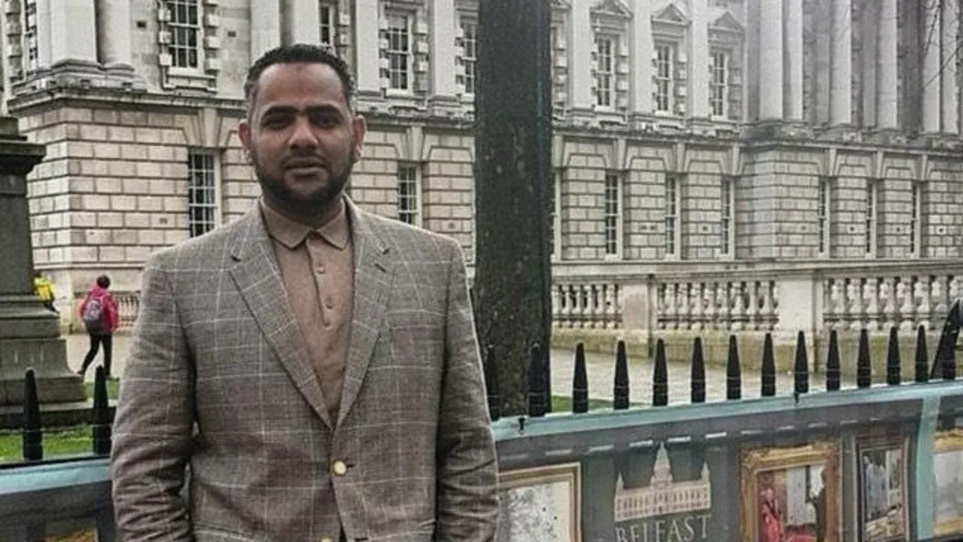 أحمد الدوش، رجل بريطاني محتجز في السعودية منذ أكثر من خمسة أشهر، يقف أمام مبنى حكومي، في سياق قضيته المتعلقة بتغريدة محذوفة.