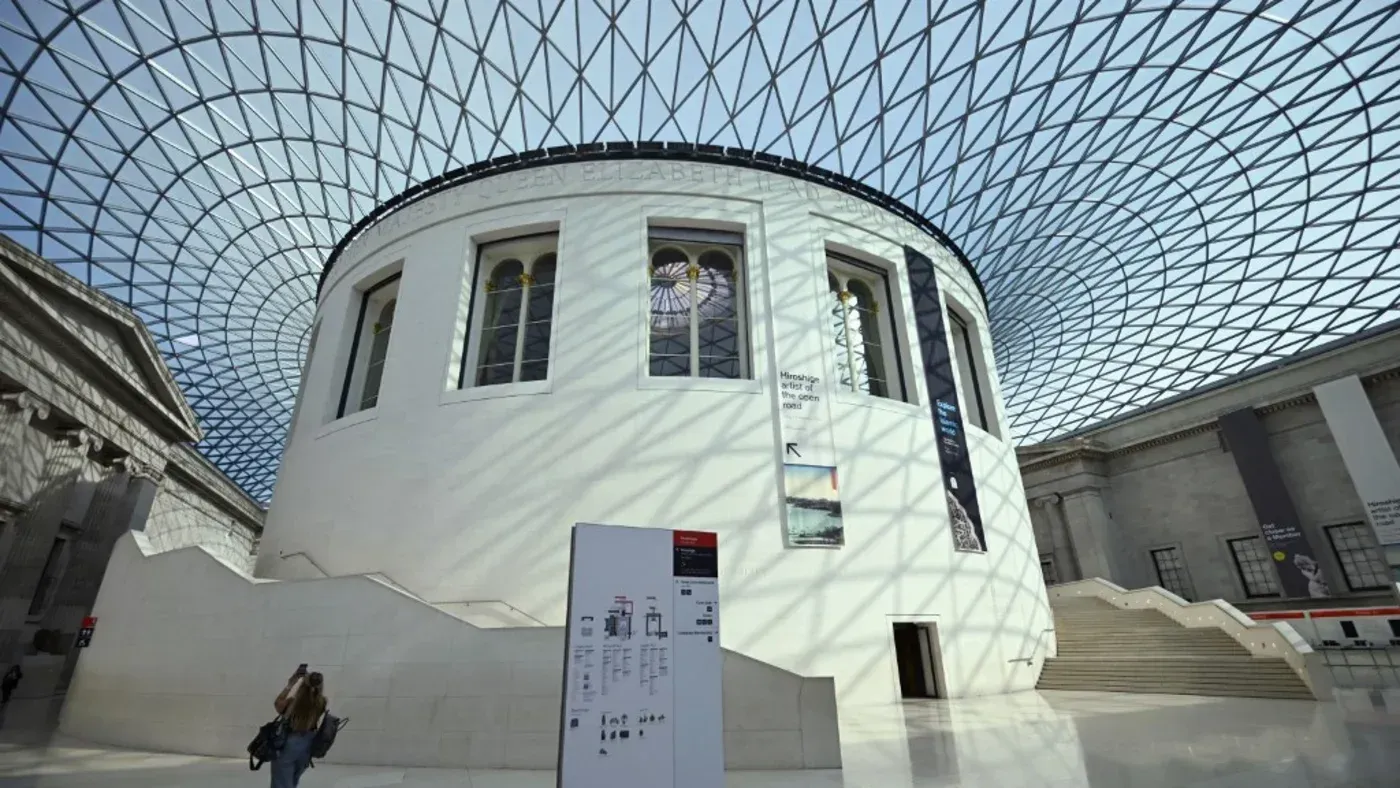 صورة توضح التصميم المعماري لمتحف البريطاني، مع قبة زجاجية تضيء الفضاء الداخلي، حيث يظهر زوار يتجولون في المعرض.