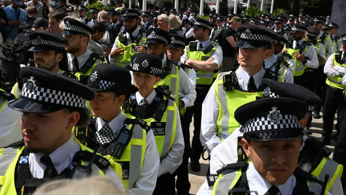 تظهر مجموعة من ضباط الشرطة في زيهم الرسمي خلال احتجاج، مع التركيز على الاستعدادات الأمنية بعد أحداث العنف الأخيرة.