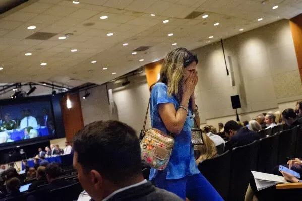 امرأة تعبر عن مشاعر الحزن أثناء جلسات الاستماع لمجلس سلامة النقل الوطني حول حادث اصطدام مروحية بلاك هوك وطائرة ركاب.