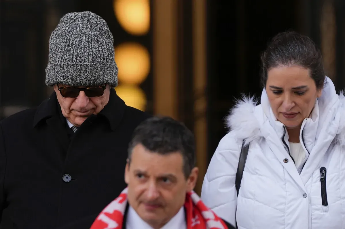أركان، رجل أعمال في بروكلين، يغادر المحكمة مع محاميه، مرتديًا قبعة وقميصًا أسود، بينما تظهر امرأة ترتدي معطفًا أبيض.