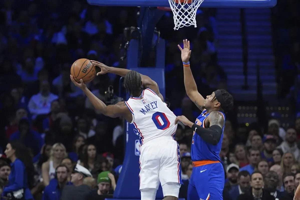 تايريس ماكسي من فريق 76ers يسجل سلة خلال مباراة ضد نيكس، بينما يحاول لاعب من الفريق المنافس الدفاع عنه.
