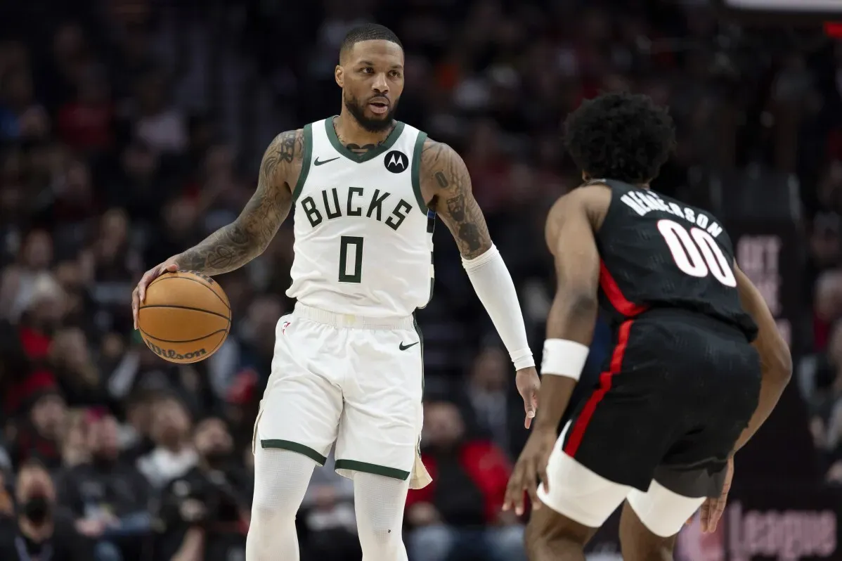 داميان ليلارد يت dribble الكرة بسلاسة أثناء مباراته مع باكس، مع تركيز على شكل اللعب ومواجهة لاعب بليزرز خلفه في مركز مودا.