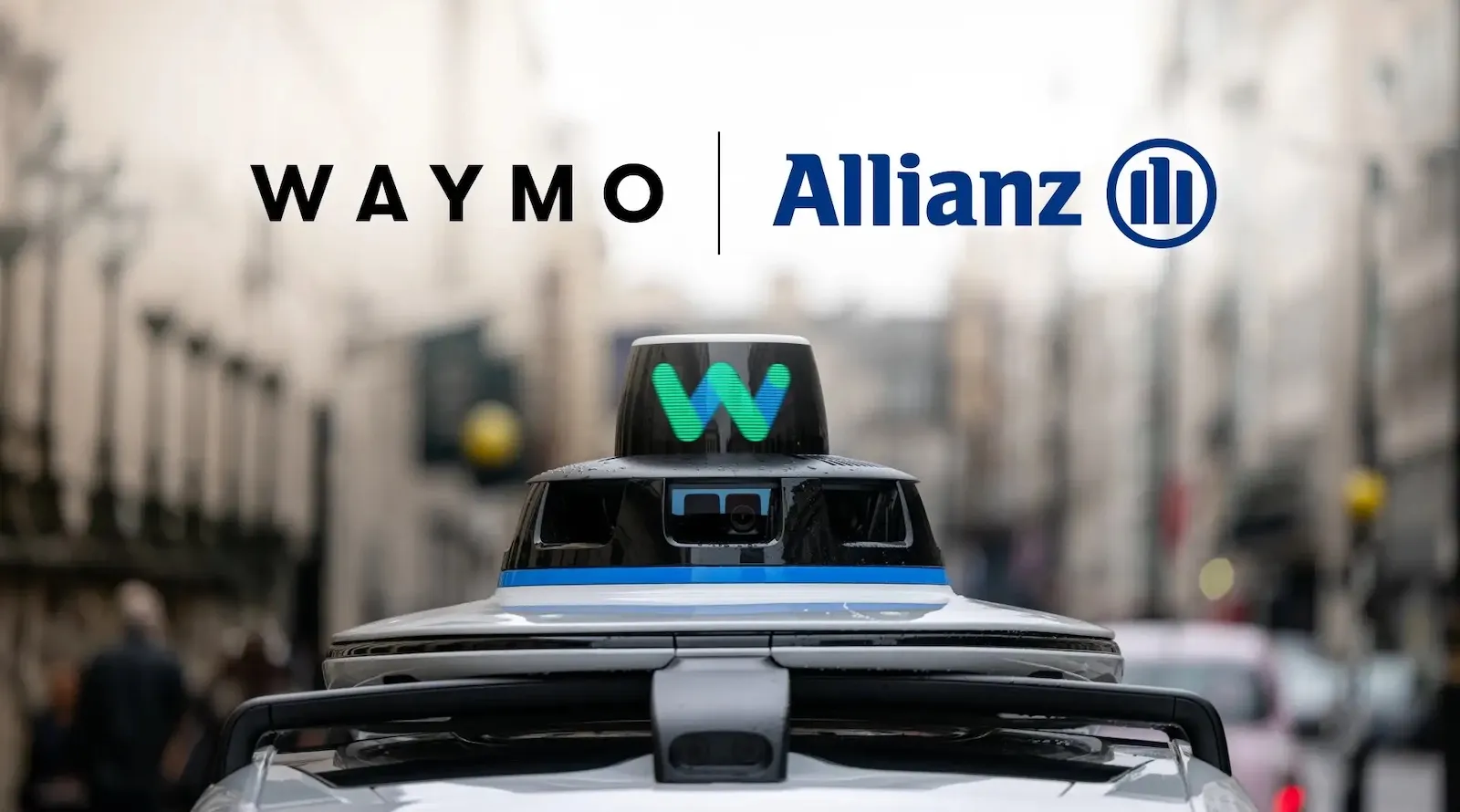 شعارا Waymo وAllianz فوق سيارة ذاتية القيادة في شارع حضري، تعبيراً عن شراكة تأمين متخصصة لدعم التنقل المستقل في أوروبا.