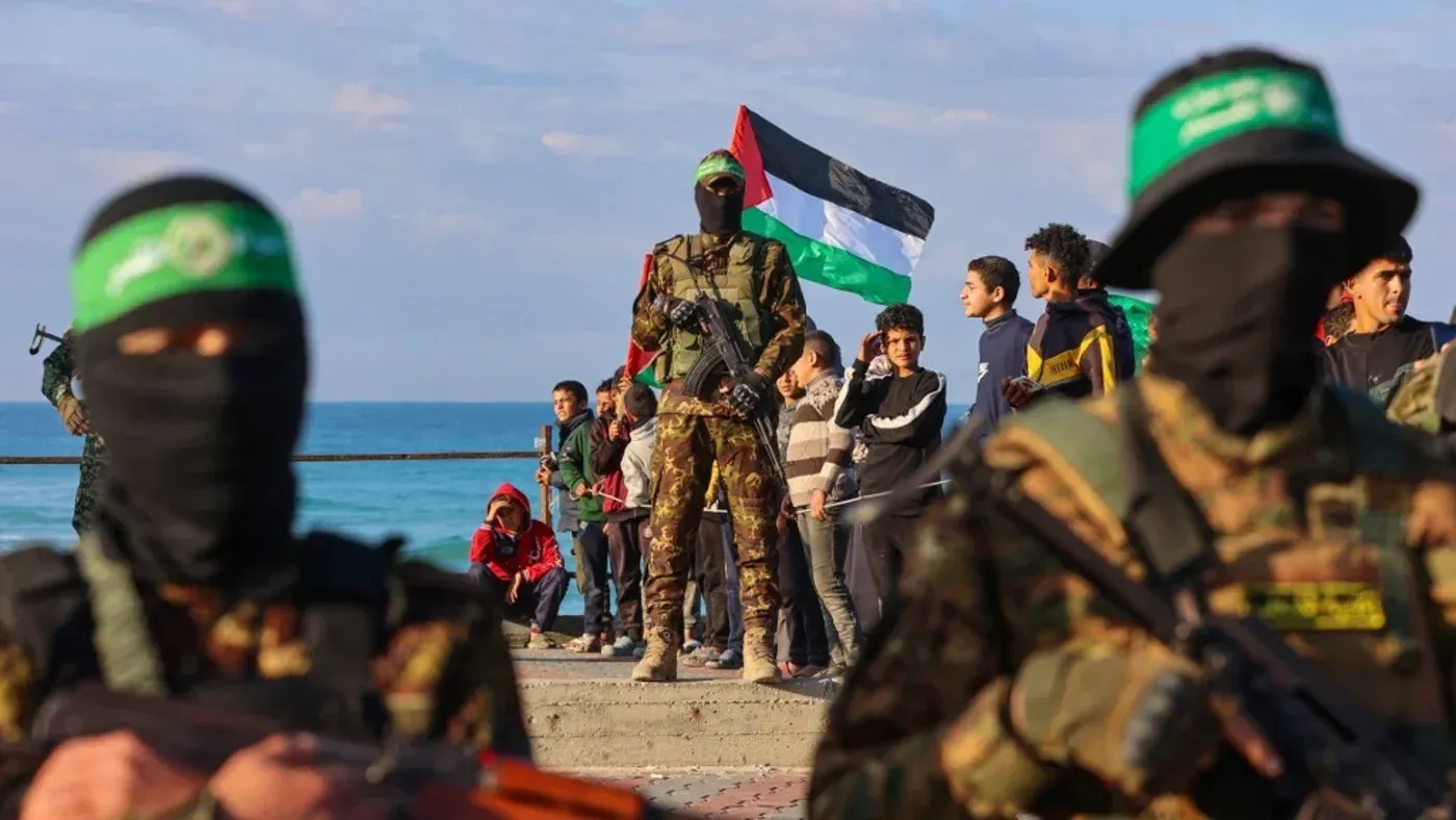 مقاتلو حماس يرتدون زيًا عسكريًا ويستعرضون في ميناء غزة بينما يرفع آخرون العلم الفلسطيني، في أجواء احتفالية بعد الإفراج عن الأسرى.