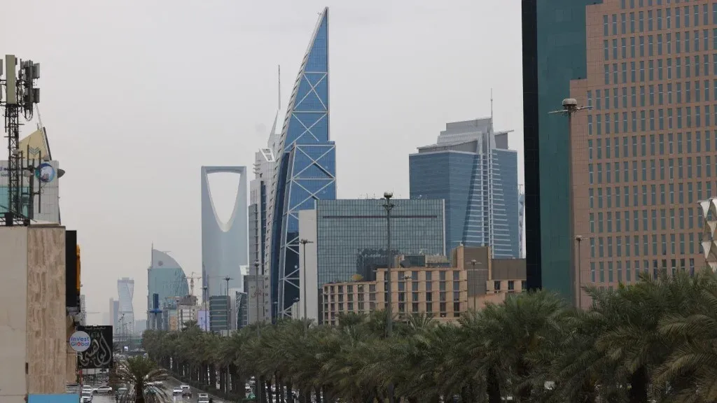 أفق مدينة الرياض مع مبانيها الحديثة وسط أجواء غائمة، يعكس التوترات الاقتصادية والسياسية بين السعودية والإمارات وتأثيرها على التحويلات المصرفية والتبادل التجاري.