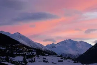 غروب شمس ملون فوق جبال مغطاة بالثلوج في شمال إيطاليا، حيث تُقام دورة الألعاب الأولمبية الشتوية في ميلانو كورتينا.