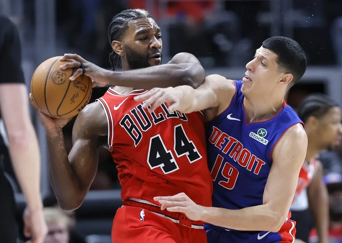 مواجهة حماسية بين لاعبي ديترويت بيستونز وشيكاغو بولز، حيث يظهر لاعب يحمل الكرة في مواجهة لاعب آخر، مع التركيز على التنافس في المباراة.