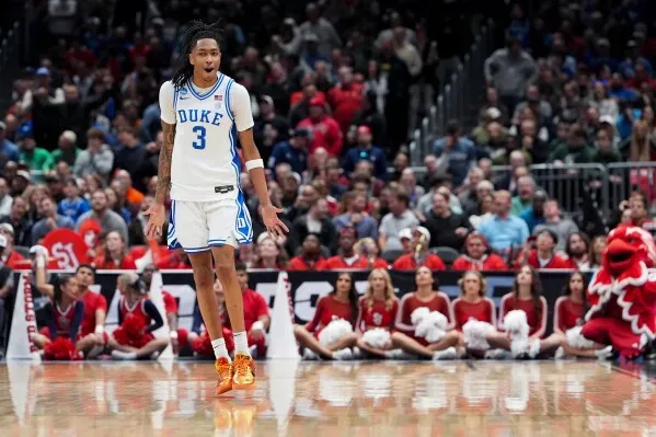 كاليب فوستر في مباراة كرة السلة، يحتفل بعد تسجيل نقطة مهمة لفريق ديوك، وسط حشد من المشجعين.