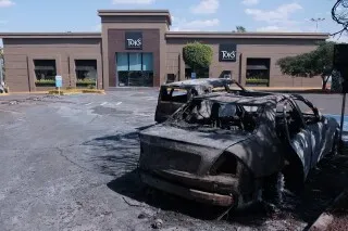 سيارة محترقة في موقف سيارات بالقرب من مطعم في غوادالاخارا، تعكس تأثير العنف المتزايد في المنطقة قبيل كأس العالم.