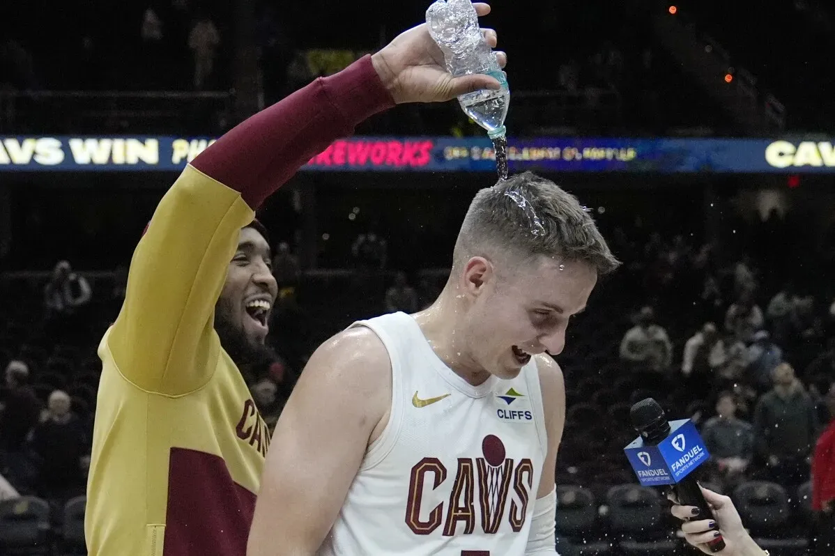احتفال لاعب كليفلاند كافالييرز بعد الفوز على دالاس مافريكس، حيث يسكب زميله الماء عليه في أجواء مليئة بالفرح.