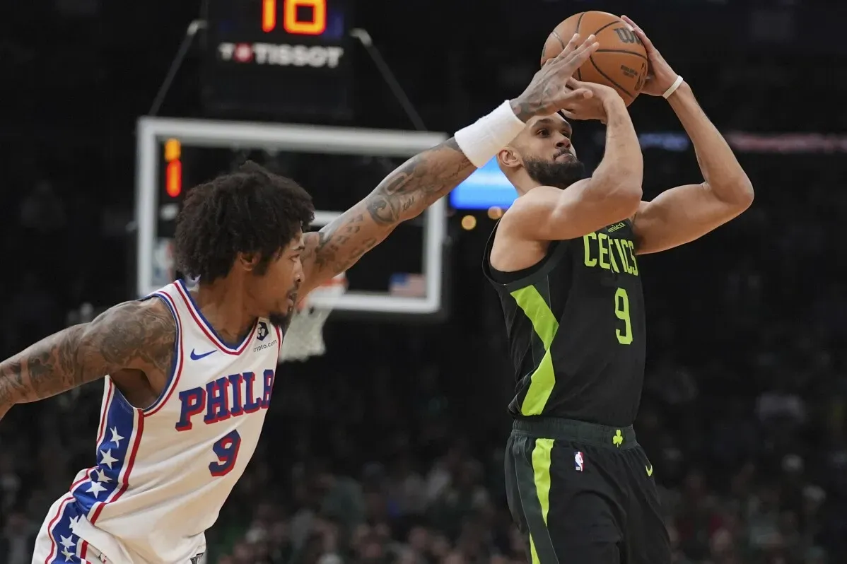 ديريك وايت يسجل نقطة خلال مباراة سيلتيكس ضد فيلادلفيا 76ers، مع وجود لاعب الخصم يعيق تسديدته.