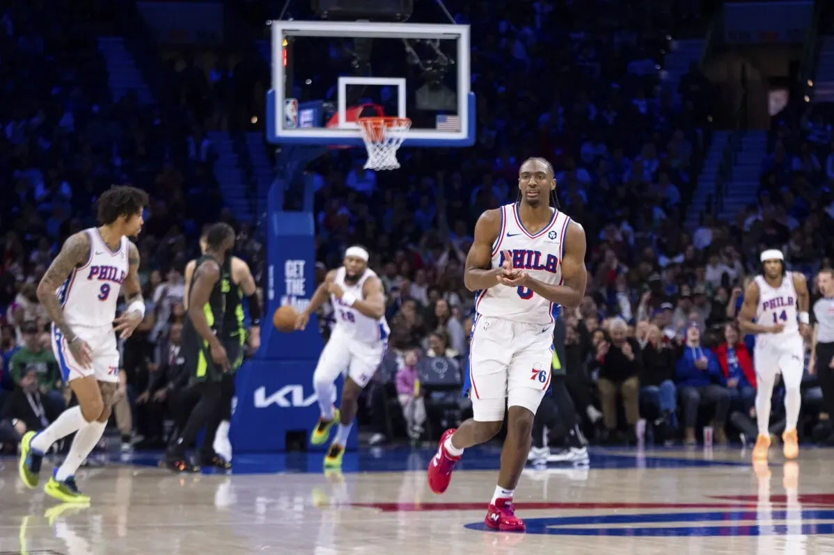 لاعبو فيلادلفيا 76ers يتجهون نحو السلة خلال مباراة ضد بوسطن سيلتيكس، مع التركيز على الأداء القوي لتايريس ماكسي.