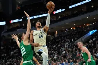 جيانيس أنتيتوكونمبو يسجل نقطة أثناء مواجهة بوسطن سيلتيكس، حيث يظهر في الصورة وهو يتجاوز مدافعين في مباراة الدوري الأمريكي للمحترفين.