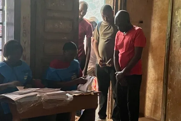 ناخبون في جمهورية إفريقيا الوسطى يتجمعون داخل مركز اقتراع، حيث يقوم موظفون بإعداد أوراق الاقتراع للانتخابات الرئاسية والتشريعية.