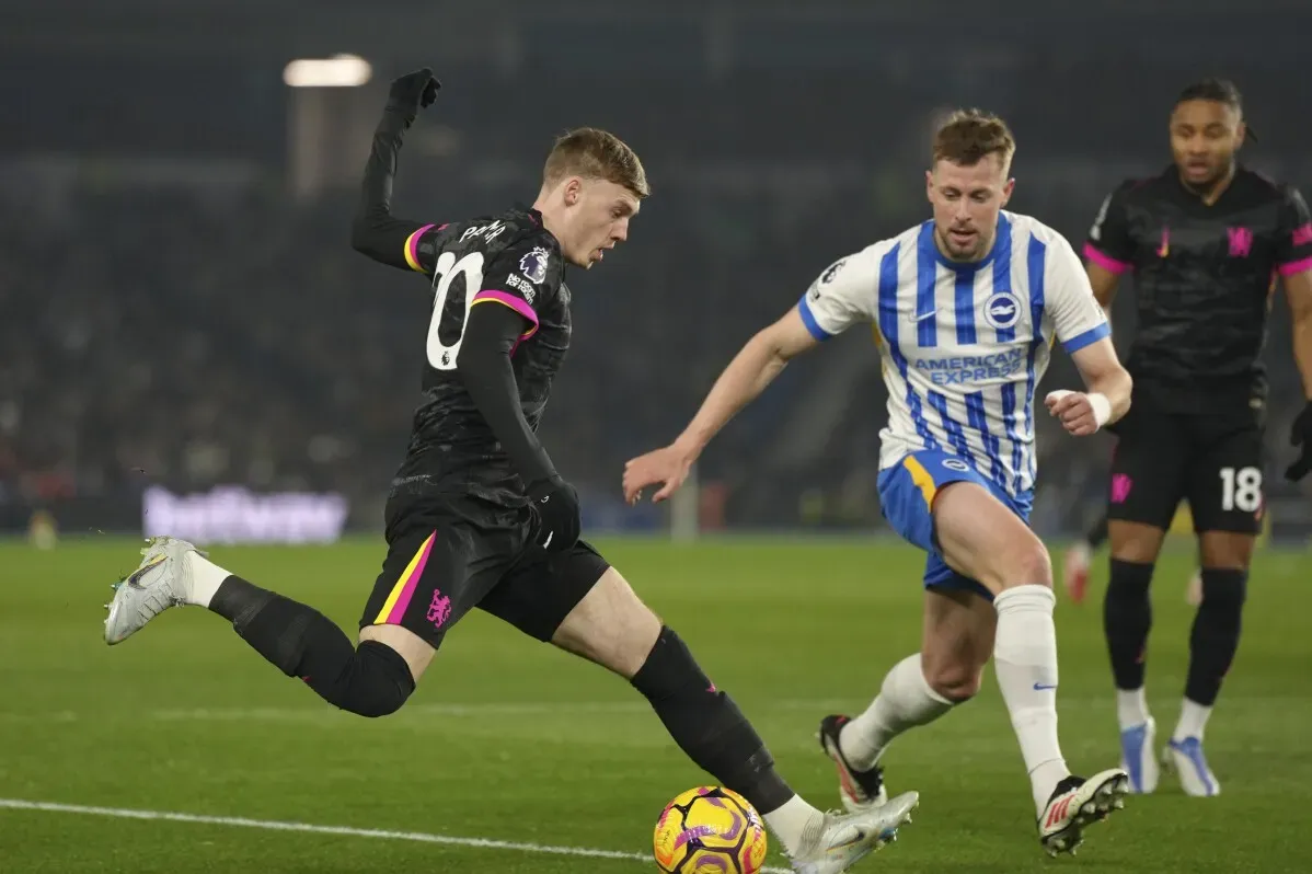 لاعب تشيلسي كول بالمر يتقدم بالكرة أثناء مباراة ضد برايتون، مع وجود مدافع يلاحقه، مما يعكس التحديات الحالية للفريق.