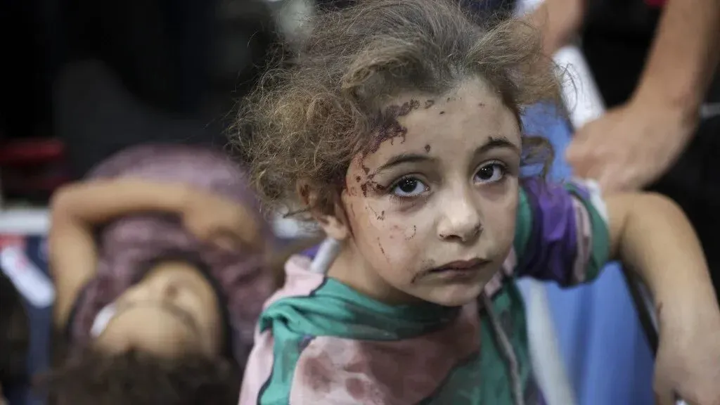 طفلة فلسطينية مصابة بجروح، تجلس في مستشفى بغزة، تعكس معاناة الأطفال الذين يحتاجون إلى علاج طبي بسبب النزاع.