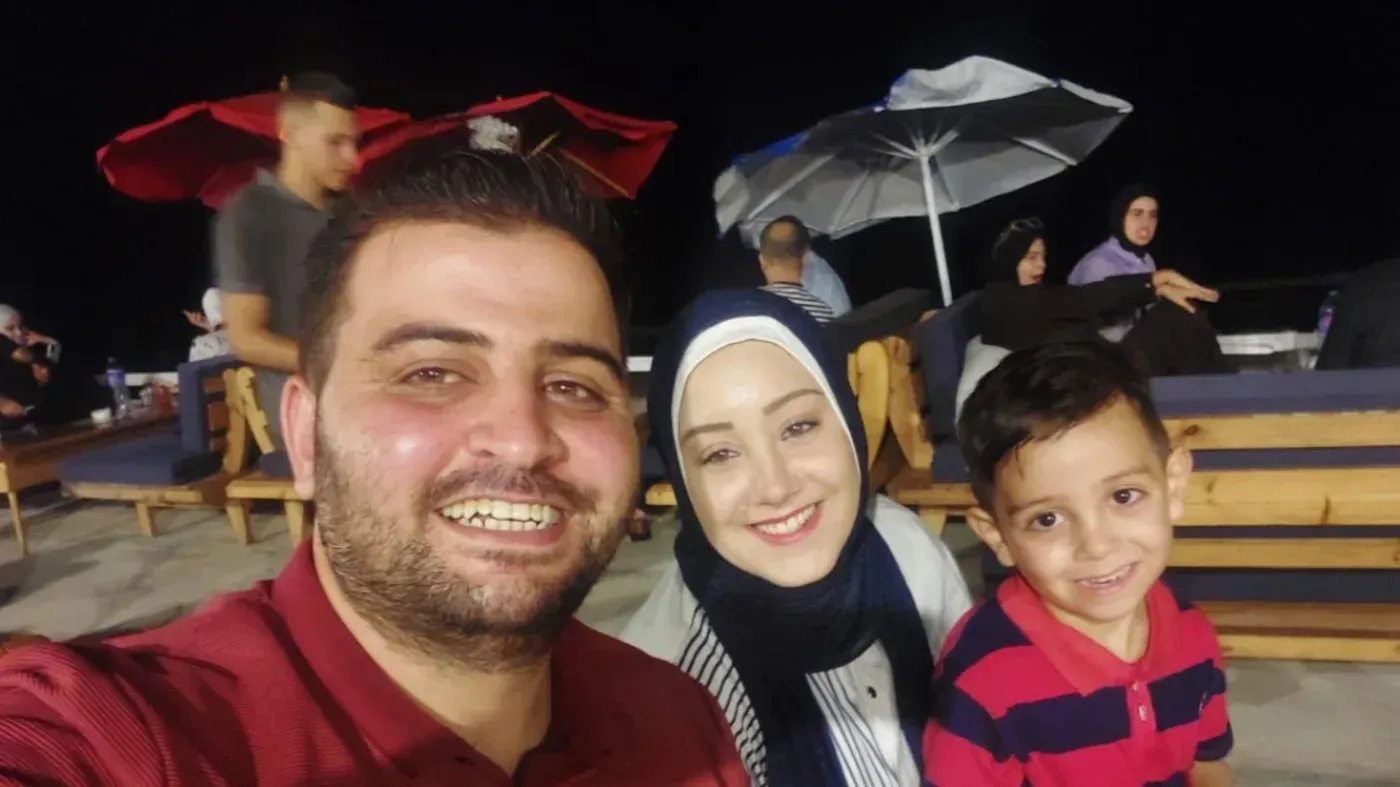 أسرة حسن عبد ربه تتشارك لحظة مع ابنهم في مكان يرتاده الناس، في حين يواجه حسن معاناة صحية مستمرة بسبب العمليات الجراحية.