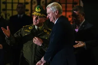 الرئيس التشيلي خوسيه أنطونيو كاست يتحدث مع مسؤول أمني خلال إشرافه على نقل 300 سجين من الفئة عالية الخطورة إلى سجن لا لاغونا الجديد ضمن جهود مكافحة الجريمة المنظمة.