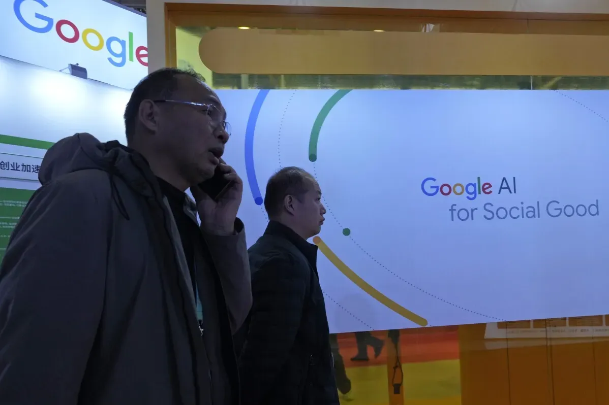 رجلان يتحدثان في معرض مع شعار "Google AI for Social Good" خلفهما، مما يعكس جهود جوجل في استخدام الذكاء الاصطناعي لخدمة المجتمع.