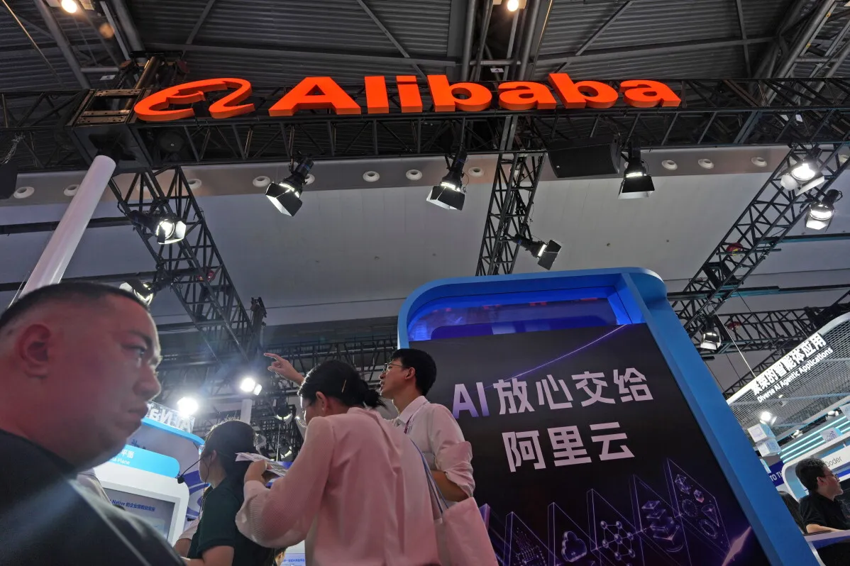 شعار شركة Alibaba وسط جناح عرض تقني في معرض، يعكس دورها في تطوير وتنظيم خدمات الذكاء الاصطناعي في الصين.