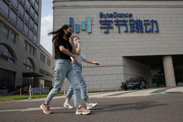 امرأتان تمشيان أمام مبنى شركة ByteDance في الصين، في ظل تشديد اللوائح على خدمات الرفيق الافتراضي المعتمدة على الذكاء الاصطناعي.