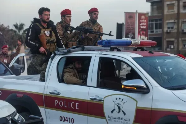 عناصر من الشرطة العسكرية في سيارة دورية، يحملون أسلحة، وسط أجواء من التوتر في حلب، سوريا، بعد تصاعد القتال.