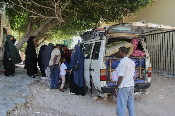 تجمع مجموعة من الأشخاص حول سيارة محملة بالأمتعة في مقديشو، في ظل تصاعد التوترات السياسية والاحتجاجات.