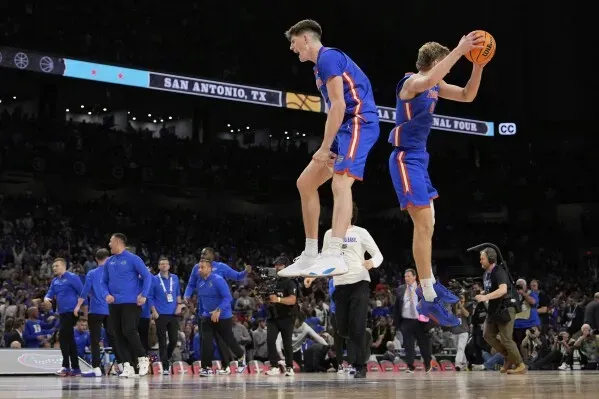 لاعبو فريق جاتورز يحتفلون بعد الفوز على أوبورن في مباراة نصف النهائي لبطولة NCAA، مع أجواء حماسية في مدرجات سان أنطونيو.