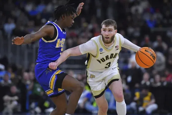 لاعب كرة سلة من فريق بوردو يت dribble الكرة بينما يتصدى له لاعب من فريق منافس، في مباراة ضمن بطولة NCAA.