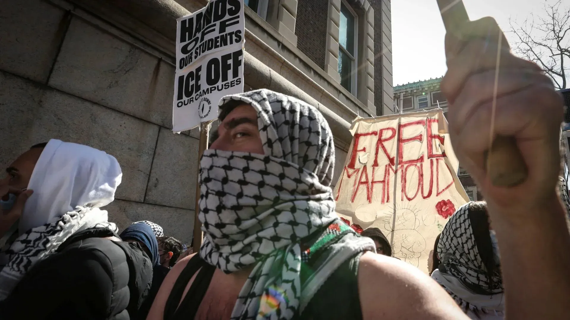 محتجون يرتدون الكوفية في جامعة كولومبيا، يحملون لافتات تطالب بإطلاق سراح محمود، وسط أجواء من التوتر بعد أحداث تأديبية.