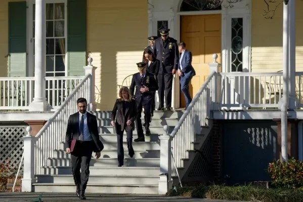 مجموعة من الضباط والمحققين يغادرون قصر العمدة في نيويورك بعد التحقيق في حادثة متعلقة بمحاولة تفجير خلال مظاهرة.