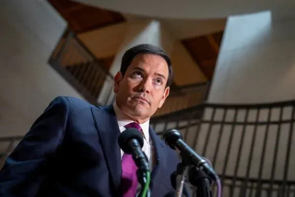 تعبير عن سيناتور يتحدث أمام الميكروفونات في مبنى الكابيتول، مع خلفية معمارية تعكس أجواء السياسة الأمريكية.