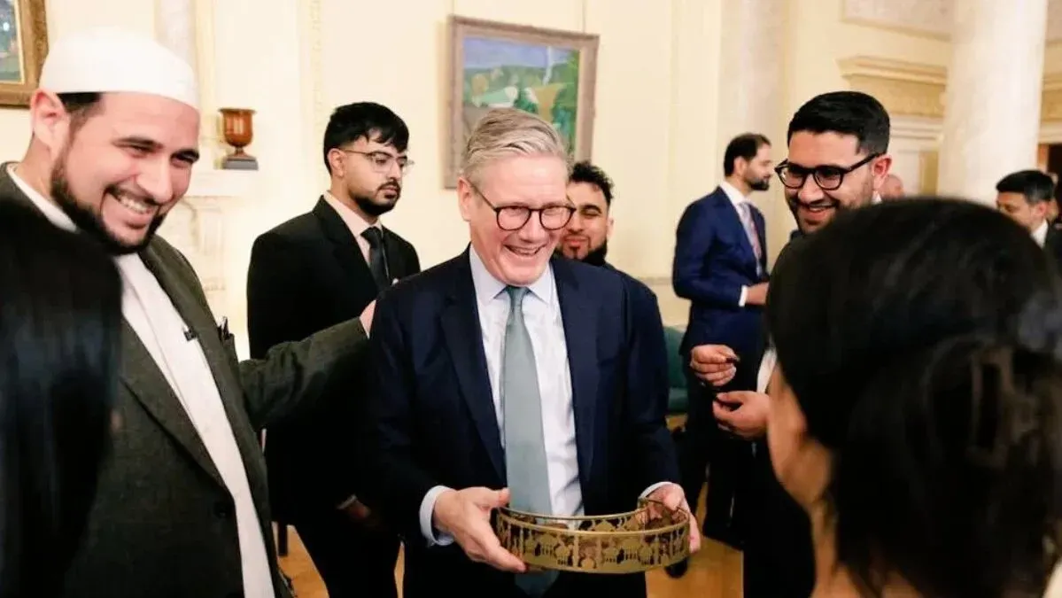 اجتماع في داونينج ستريت حيث يتحدث الإمام آدم كيلويك مع رئيس الوزراء كير ستارمر ومجموعة من الحضور، مع جو من التفاعل الإيجابي.