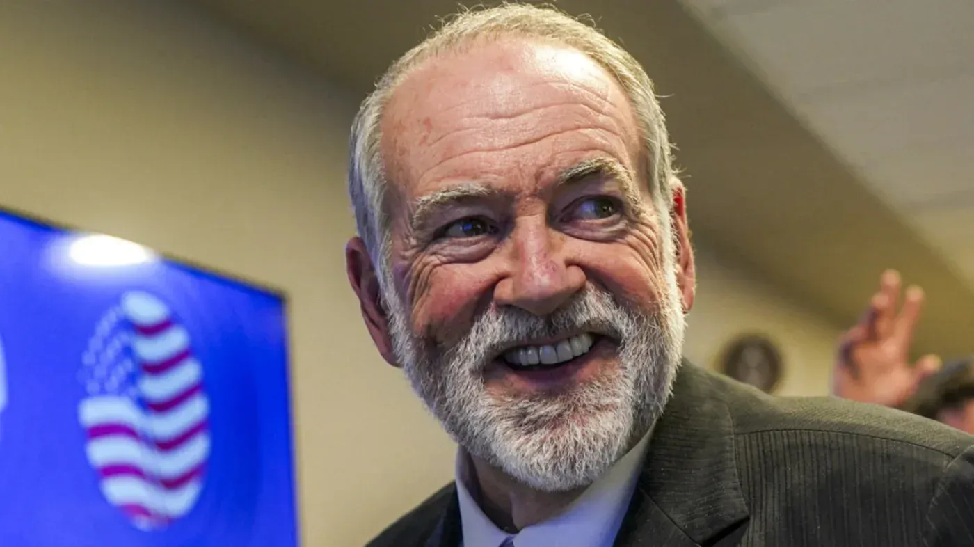 مايك هاكابي، السفير الأمريكي لدى إسرائيل، مبتسم أثناء حديثه عن الضفة الغربية المحتلة، مما يعكس السياسة الأمريكية المتغيرة.