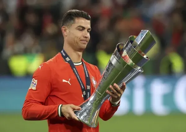 رونالدو يحمل كأس دوري الأمم الأوروبية بفخر، في لحظة احتفالية بعد فوز البرتغال، مع التركيز على إنجازاته الرياضية.