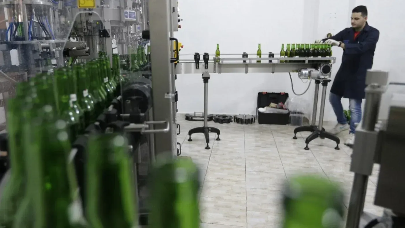 عامل يعمل في مصنع تعبئة زجاجات الكحول في دمشق، حيث تم الإعلان عن حظر بيع الكحول في المدينة باستثناء بعض الأحياء المسيحية.