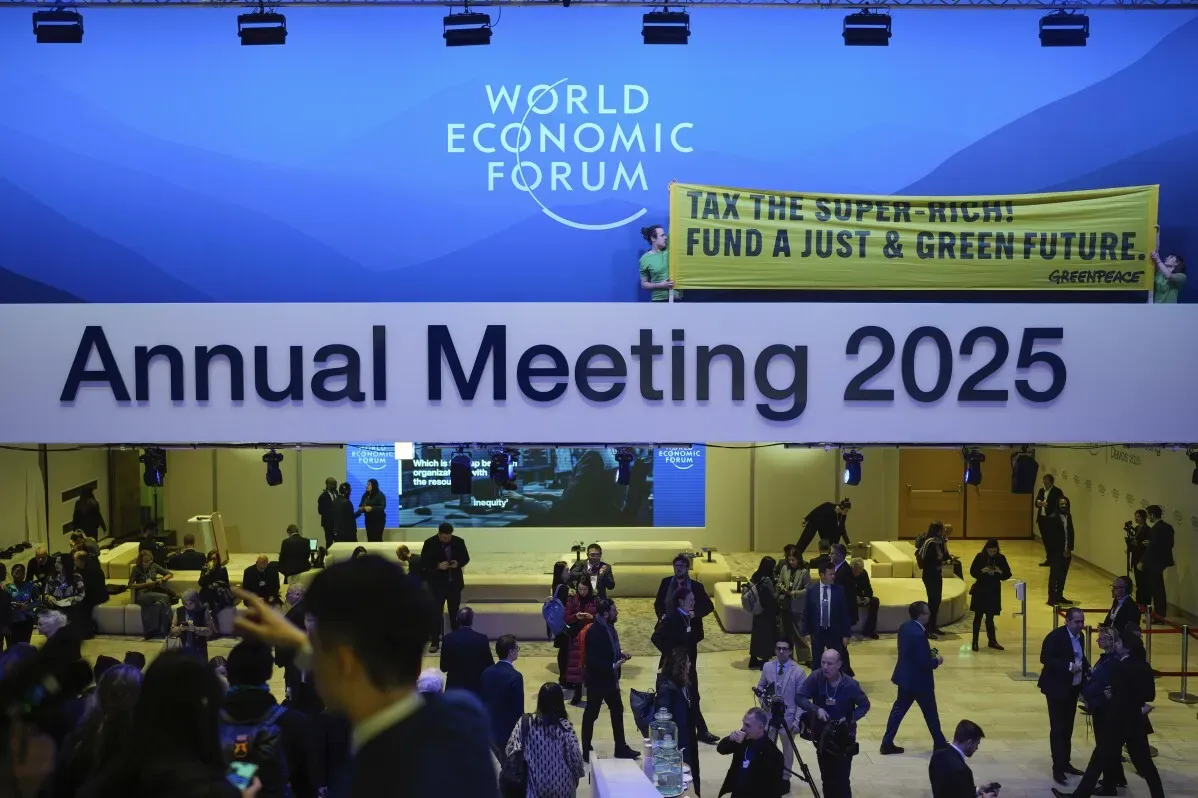اجتماع المنتدى الاقتصادي العالمي 2025 في دافوس، حيث يتجمع القادة لمناقشة قضايا مثل تغير المناخ والذكاء الاصطناعي، مع لافتة تدعو لضرائب على الأغنياء.