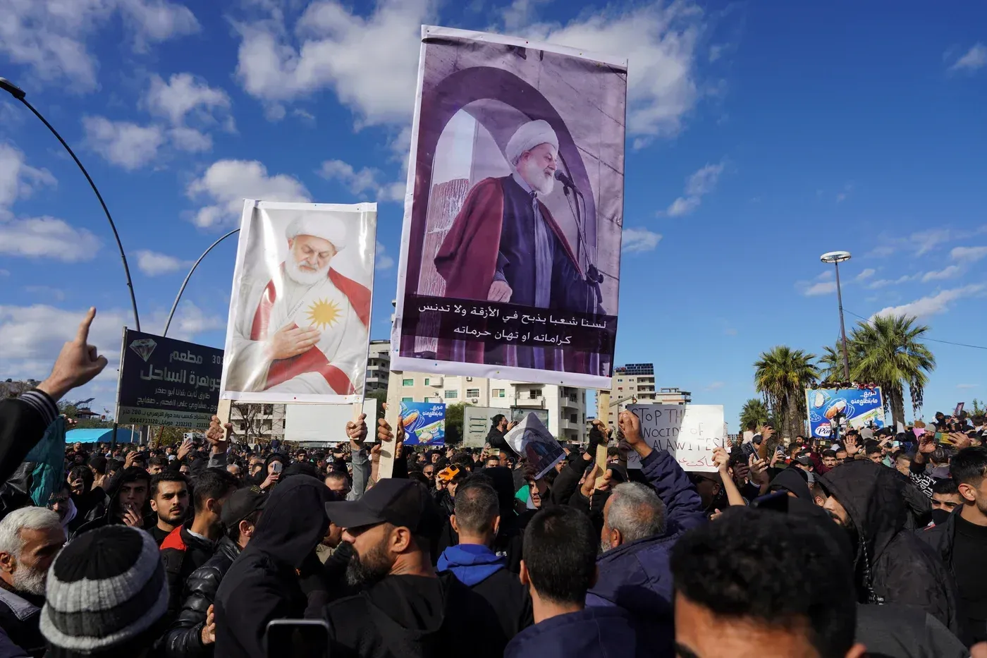 تجمع حشود كبيرة في اللاذقية وطرطوس، حيث يحمل المتظاهرون لافتات تعبر عن مطالبهم، وسط أجواء من التوتر الطائفي.