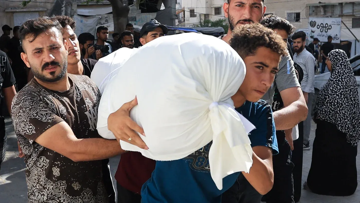 شبان فلسطينيون يحملون مساعدات إنسانية في شوارع غزة، وسط استمرار الهجمات الإسرائيلية وتدهور الأوضاع الإنسانية.
