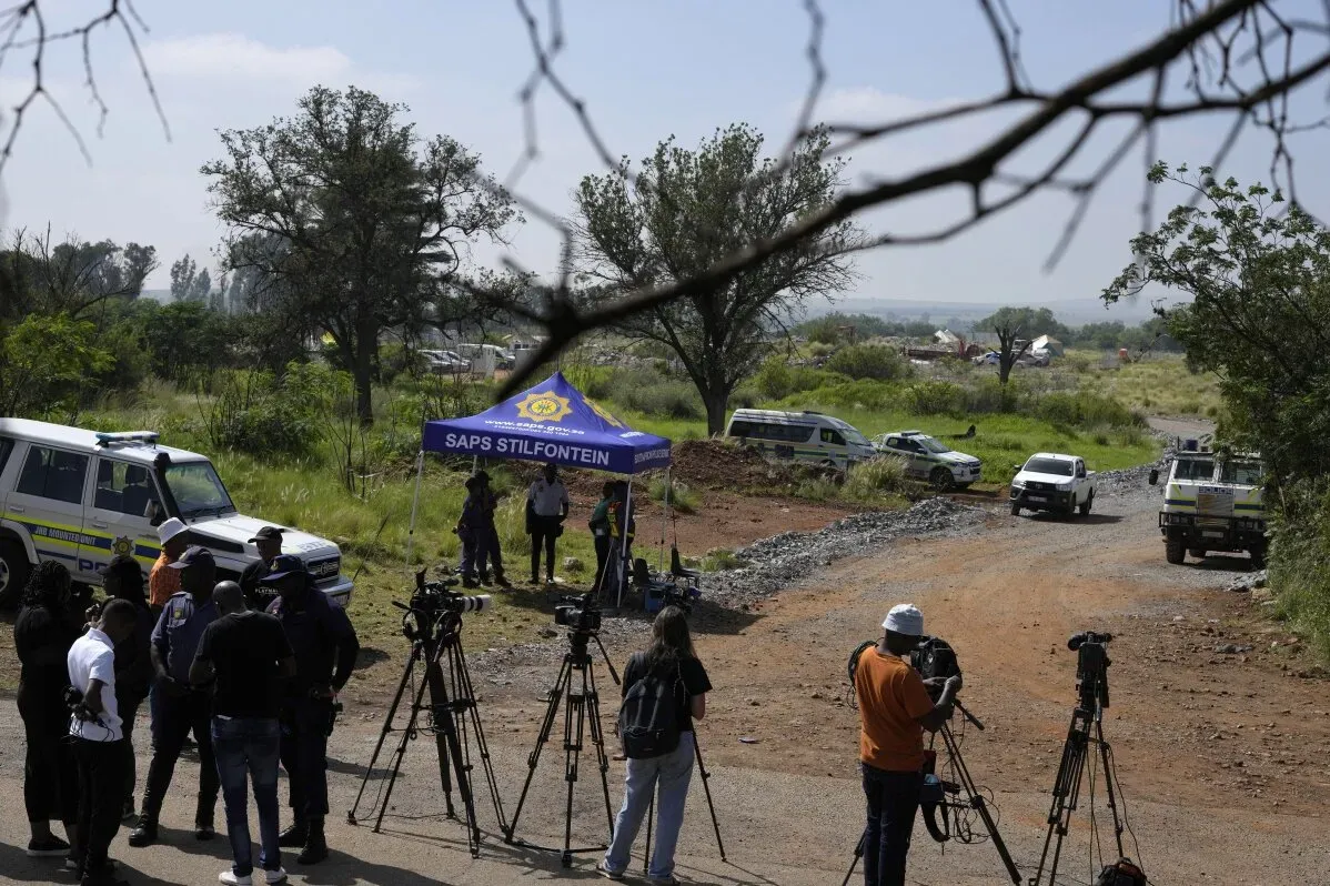 تجمع الصحفيون والشرطة تحت خيمة تحمل شعار \"SAPS Stilfontein\" أثناء تغطية حادثة المناجم في جنوب أفريقيا، حيث ارتفعت حصيلة القتلى.