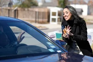 امرأة مبتسمة تتحدث مع ناخب داخل سيارة خلال حملة انتخابية في هيوستن، حيث تتنافس على مقعد مجلس النواب الأمريكي.